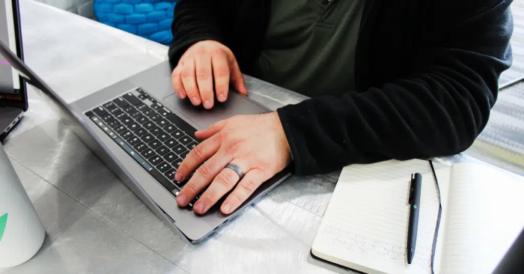Project Management Tips: How to Prepare for Your New Custom Software Project 1 Worker at desk writing about project management tips and how to prepare for a new custom software project.